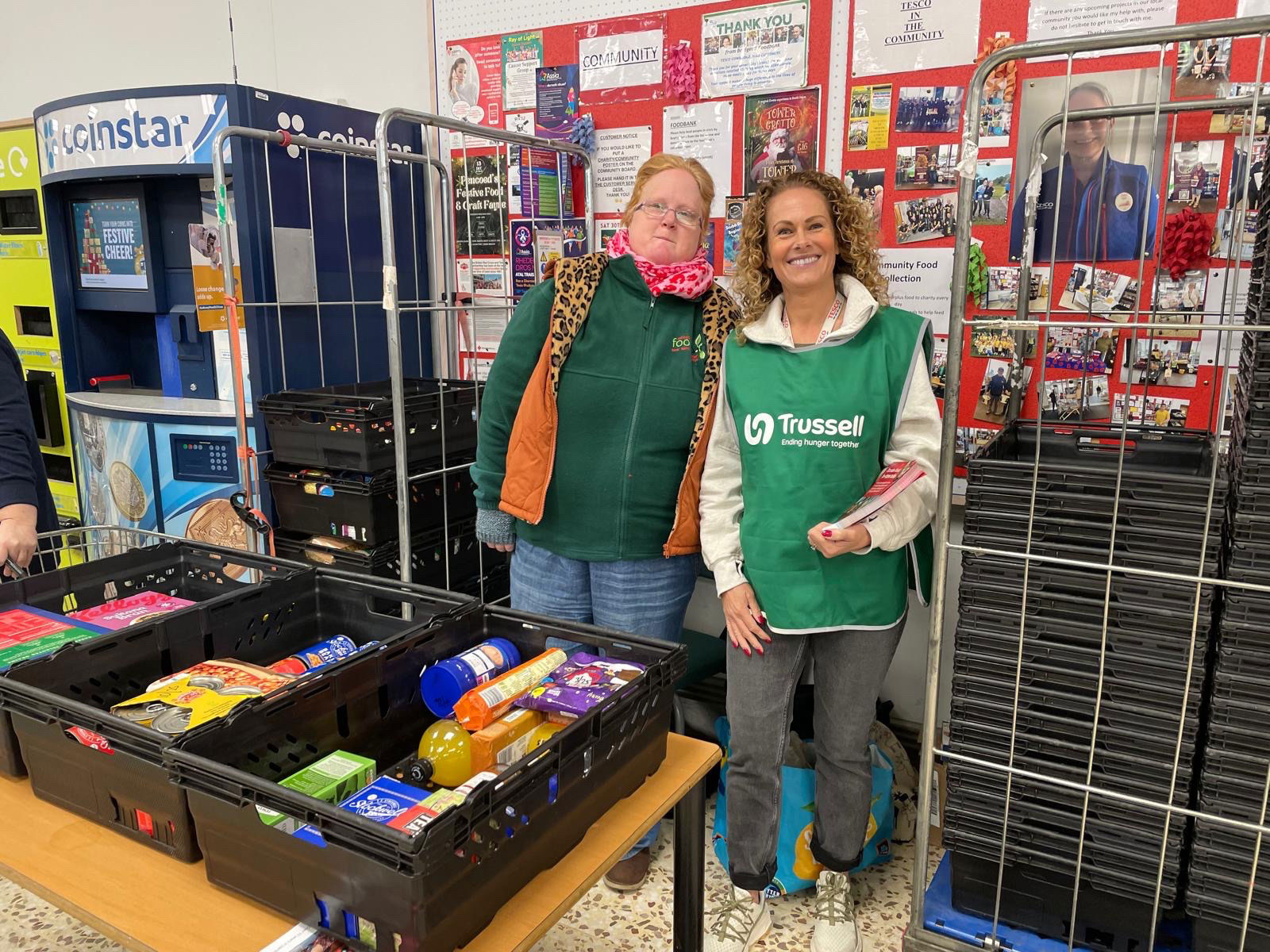 Two food bank volunteers at supply counter